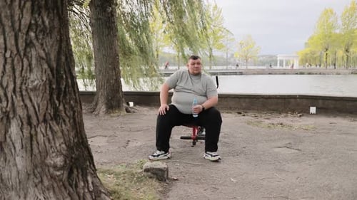 One Overweight Man in the Park Exercising Male Large Caucasian Man Working Outdoors Weight Loss