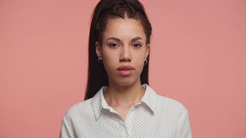 Young Adult Closes Eyes on Pink Background