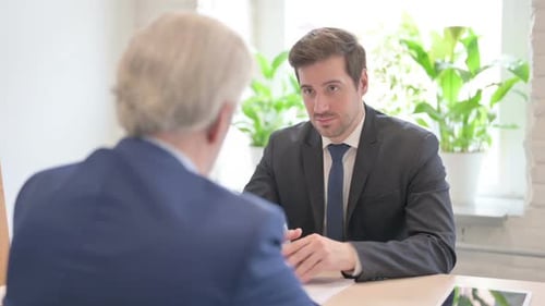 Älterer alter Geschäftsmann im Gespräch mit einem älteren alten Geschäftsmann