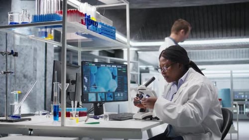 Scientist Analyzing Samples in Laboratory Setting with Microscope and Chemicals