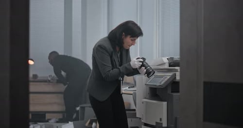 Woman Examines Digital Camera in Office Crime Scene