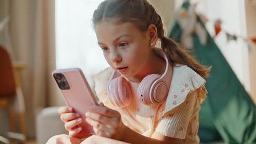 Child Happily Interacts with Smartphone at Home