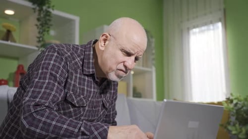 Senior Man Using Laptop at Home