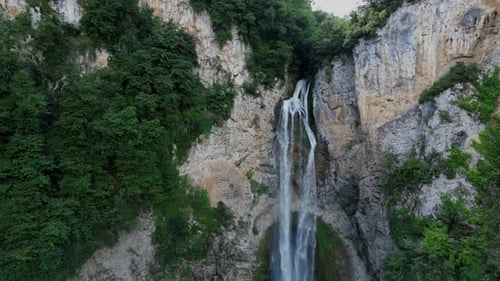 Aerial View Of A Beautiful Waterfall Surrounded By Forest