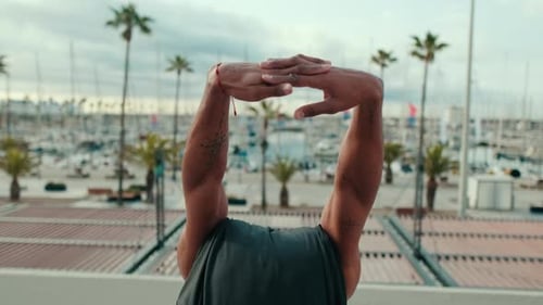 Muscular Man Stretching in Sunny Marina