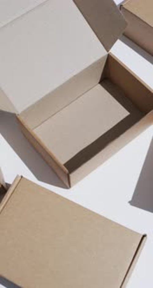 Vertical video of cardboard boxes with copy space over white background