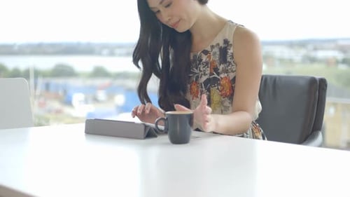 MS TU Young woman sitting in office and using digital tablet