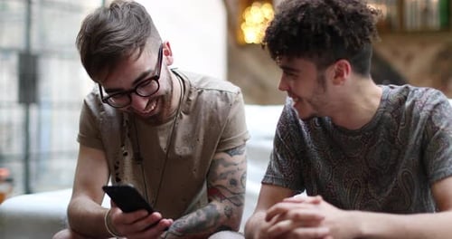 Two Young Men Chatting and Looking at Phone