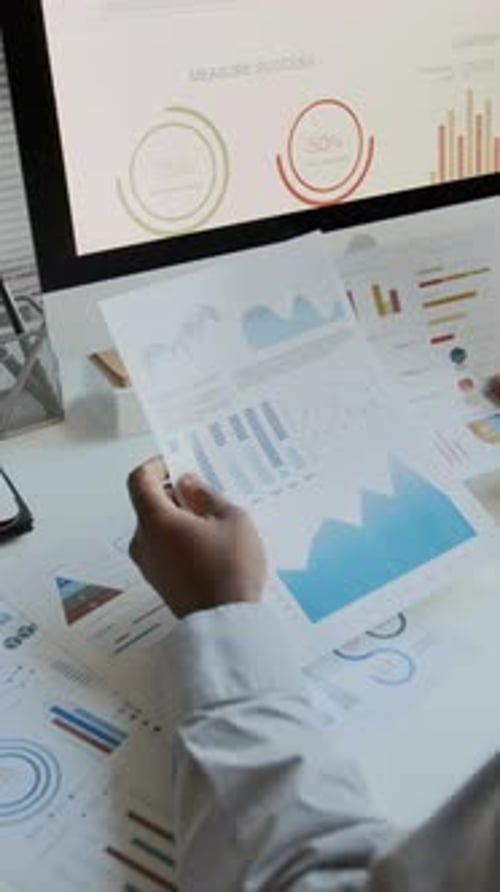 Hände eines männlichen Geschäftsanalysten, der Finanzdiagramme studiert