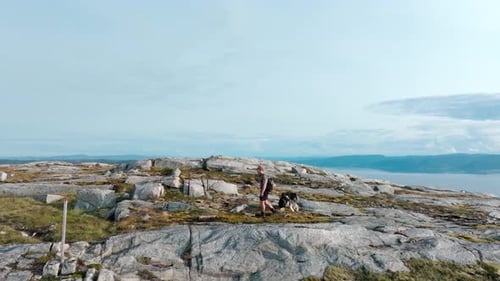 Man And Pet Dog On A Hike At Mountain Blaheia In Nordland, Norway. wide