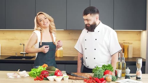 Junge Frau und Mann bereiten Essen zu und veranstalten eine Kochshow, die Blogger aus Kitchen Healthy streamen