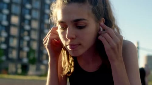 Woman With Earbuds Using Phone on Exercise Mat