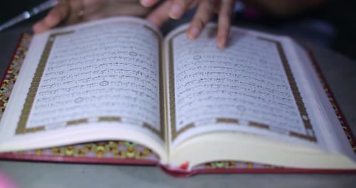 Öffne und suche nach Surah Al Quran. Junger Muslim rezitiert im heiligen Monat Ra den Koran oder Koran