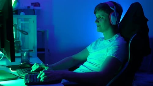 Young Adult Gaming on Computer at Home at Night