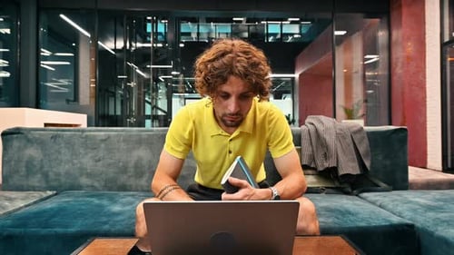 Young Adult Working on Laptop in Modern Office