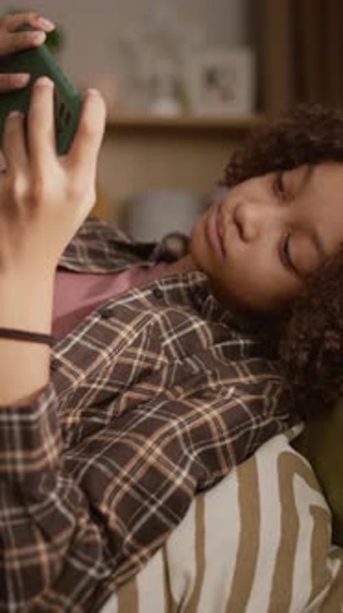 Teen Lying on Couch Relaxing and Using Phone