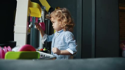 Cute Child Playing at a Toy Kitchen