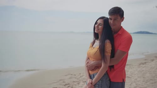Couple young man and woman dating looking sea on the beach travel