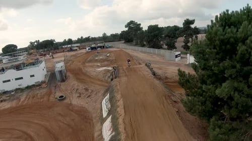 Motocross rider jumping over a dirt ramp on a circuit. Aerial shot. Slow motion. Portugal.