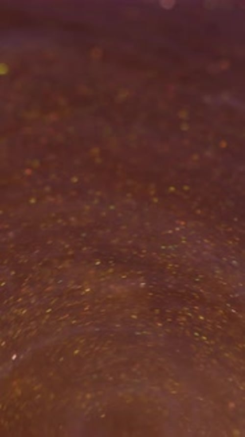 Abstract shimmering copper and gold liquid with sparkles