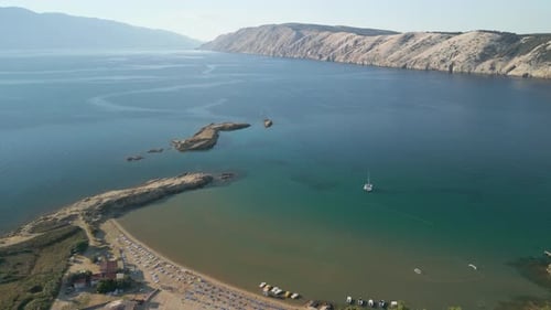 Imagens aéreas com drone na Croácia voando suavemente sobre um quadrado de areia fina e mar calmo
