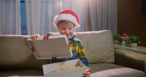 Happy Cute Child Delighted with Surprise Opens a Box Christmas Gifts and Falls Down with Happiness
