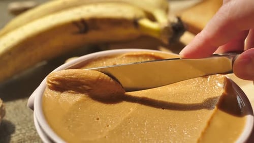 Closeup of a Table Knife Taking Peanut Butter From a Jar Use a Knife to Scoop and Spread the Peanut