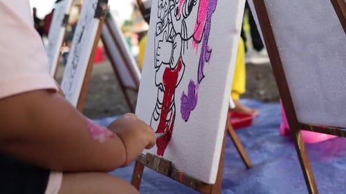 Little Child Painting With Brush in public area