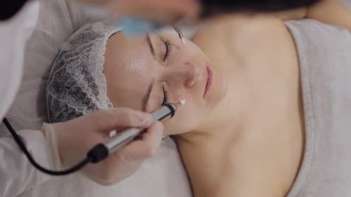 Middleaged Woman Receiving Micro Currents Facial Skin Treatment From Beautician in Spa Clinic