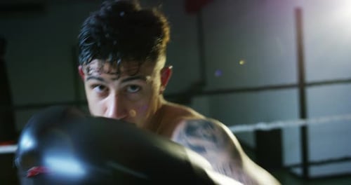 Professioneller junger Boxer im Ring, wird die Technik der Schläge, der Verstrebungen und des Schutzes üben