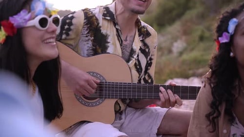 Friends Singing and Playing Guitar at Sunset