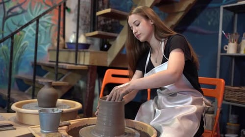 People Creating Pottery in Studio. Female artisan creating handmade ceramics in pottery workshop