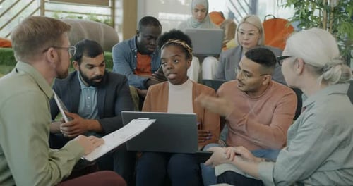 Diverse Group of People Employees Sharing Ideas Brainstorming and Using Laptop in Coworking Center