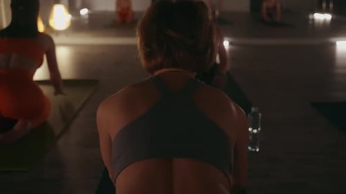 Adults Doing Yoga Poses in Warmly Lit Studio