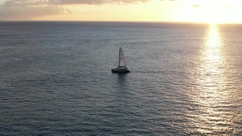 Stunning Aerial View of a Sailboat at Sunset