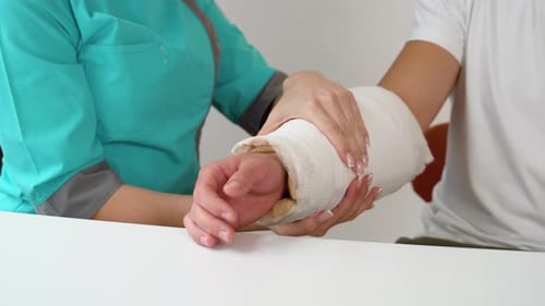 Nurse Examining Patient's Arm Cast Close Up