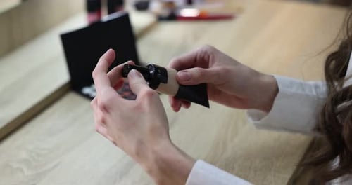 Woman Opens Cosmetic Tube in Home Interior Setting