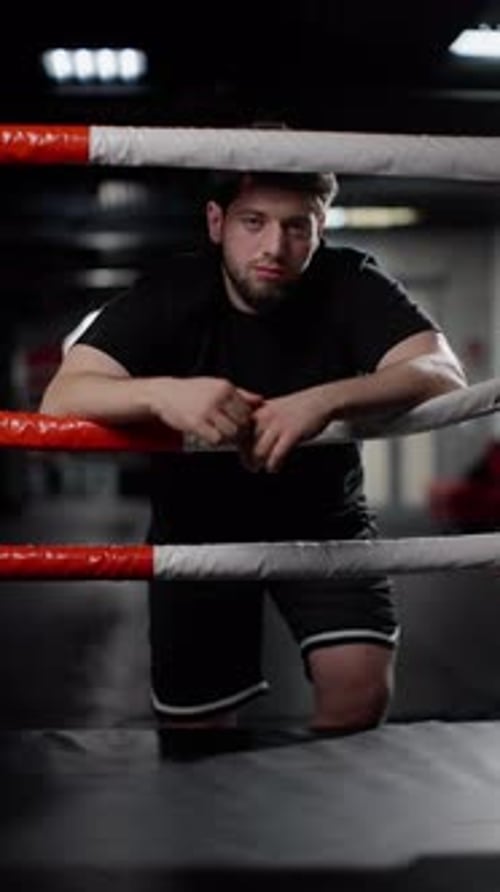 Muscular Man Leaning on Boxing Ring Rope