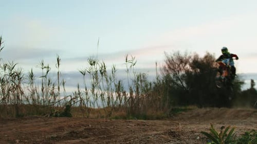 Motocross Rider Jumping on Rural Dirt Track