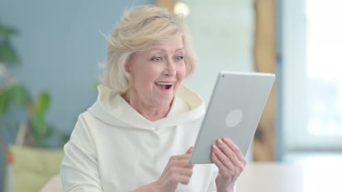 Portrait of Senior Old Woman Celebrating Success on Tablet