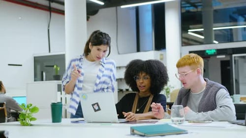 Group of Young Colleagues Working in Team and Using Laptop in the Office