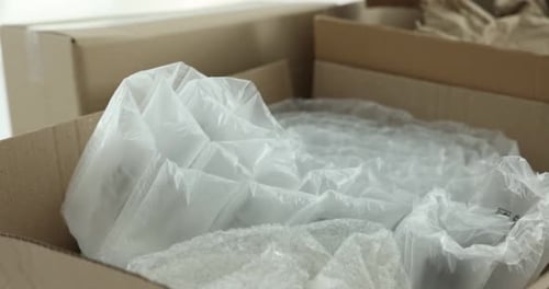 Different packaging materials on white background, closeup. Camera moving in and right