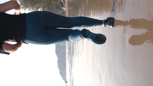 Rear View of Woman Jogging Along the Beach