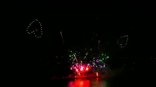 Brilliant Fireworks Exploding over Water at Night
