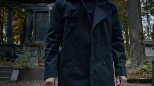 Mourning Man Leaning on Grave in Cemetery