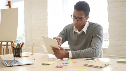 Young Adult Using Tablet in Bright Workspace