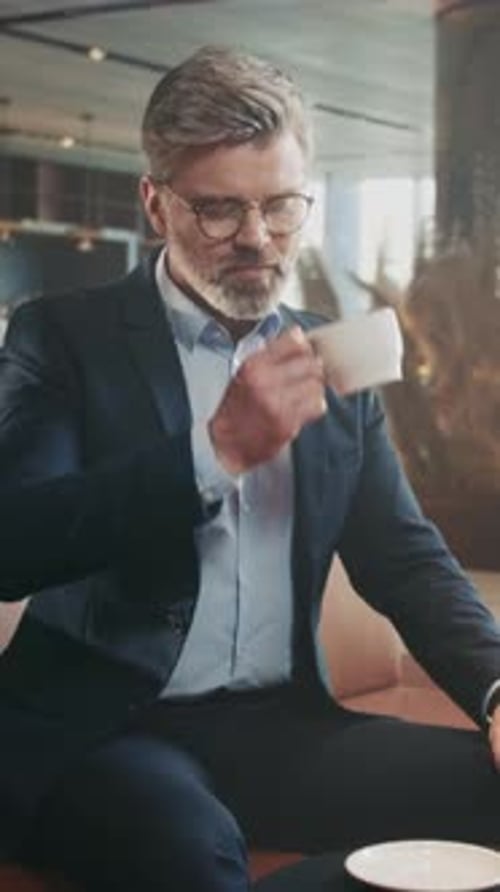 Stylish businessman drinking coffee in upscale cafe