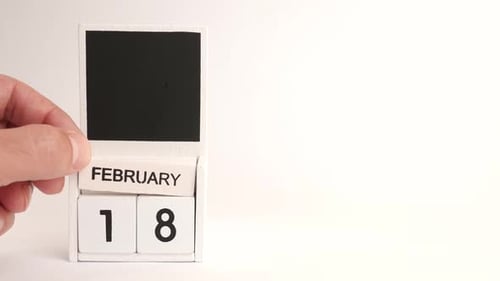 Hand Changing Calendar to February 18 Date