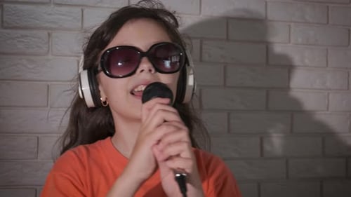 Child Singing Into Microphone With Headphones On