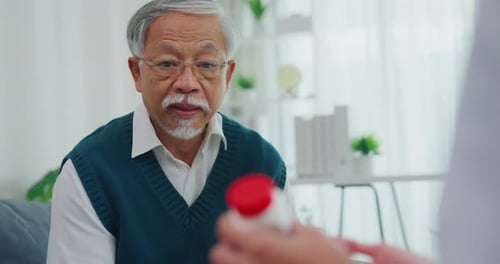 Senior Man Consults Doctor About Medication in Home